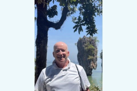 Kurt Waters &#039;77 stands and smiles with Khao Phing Kan in the background.