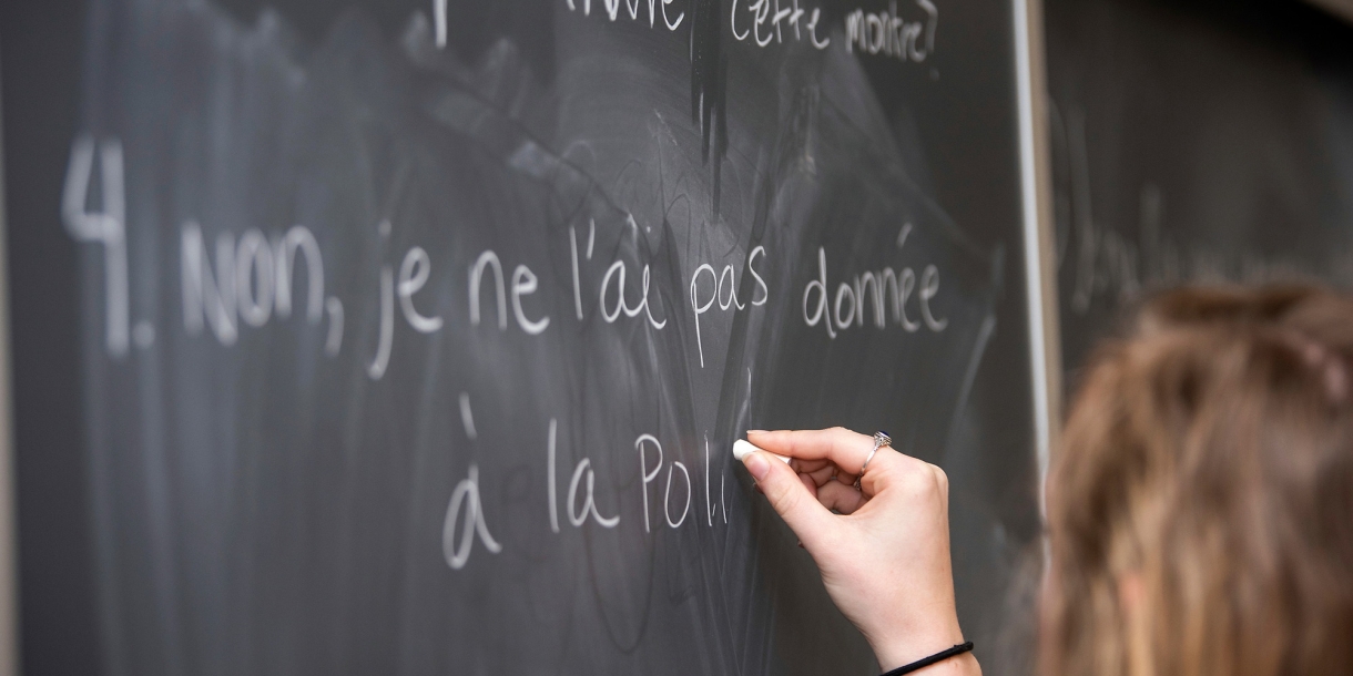 Student writing on the board in French class