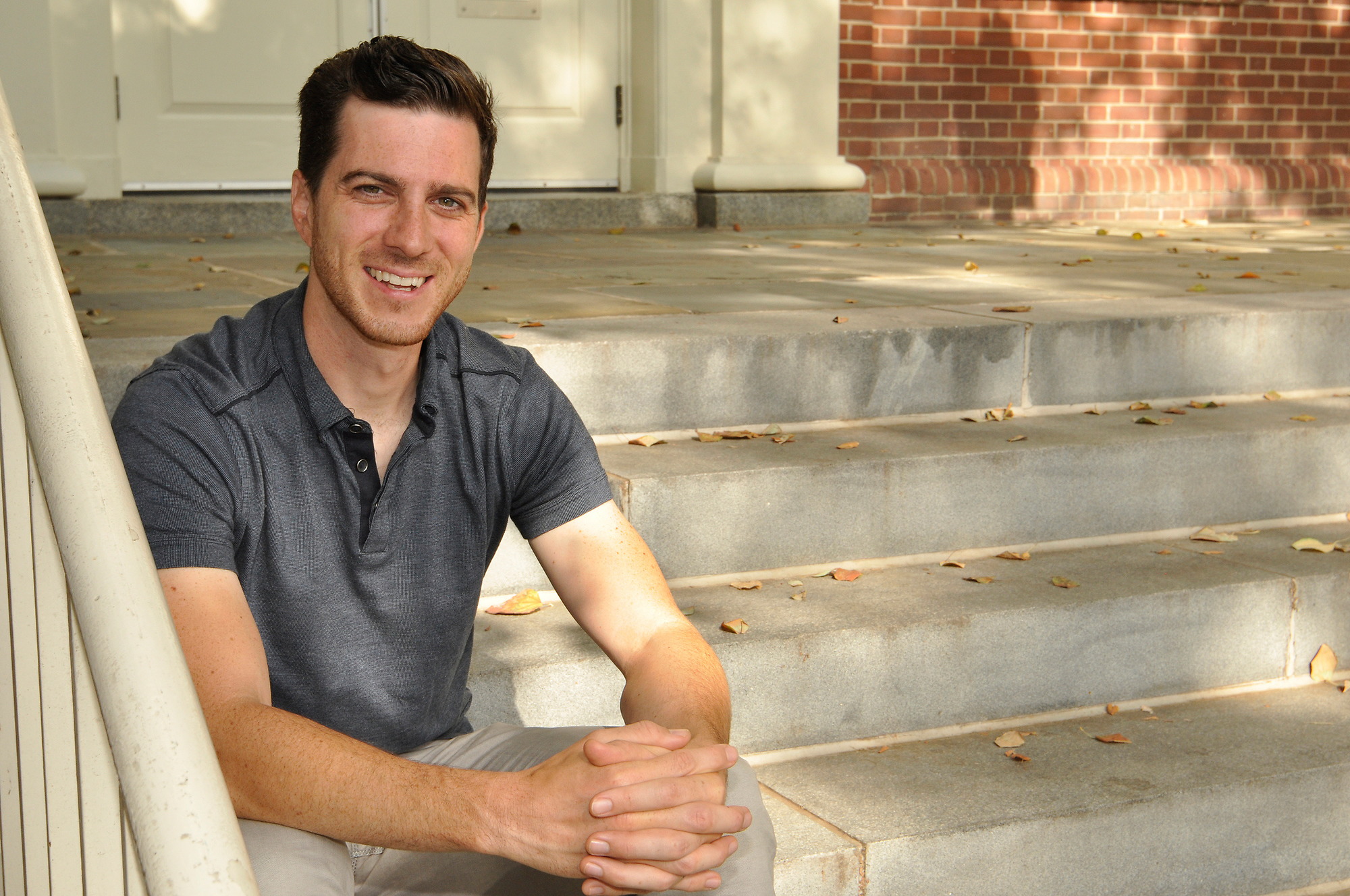 Person sitting on a step and smiling.