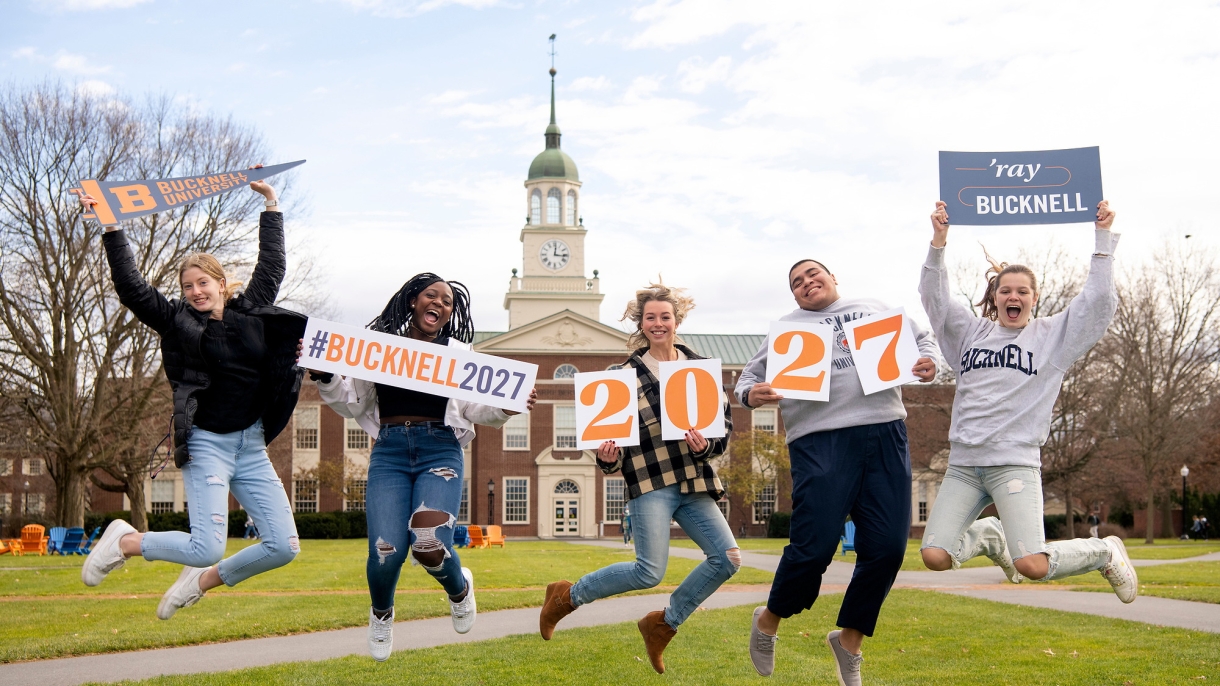Students jumping in excitement on Malesardi Quad with welcoming signs for the Class of 2027.