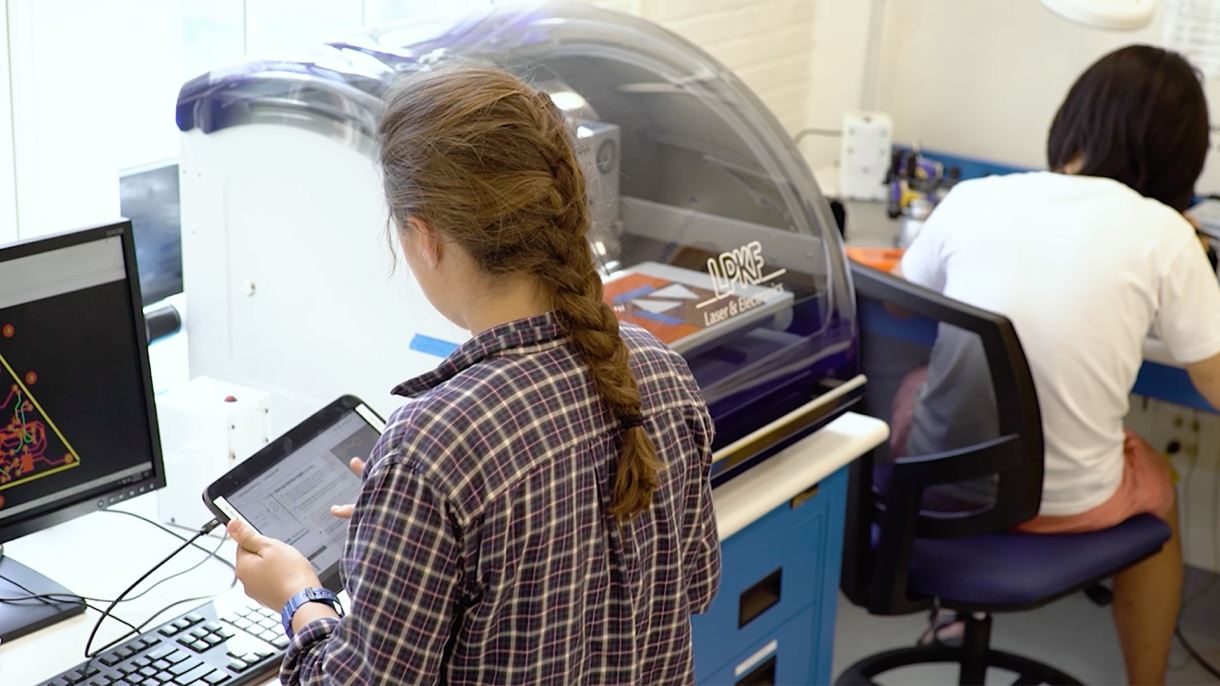 Student using iPad and computer.
