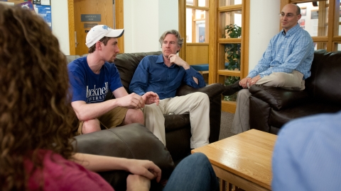 Students and professors talk inside a building