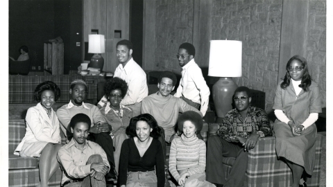 An archival photo shows a group of black students smiling at the camera. 