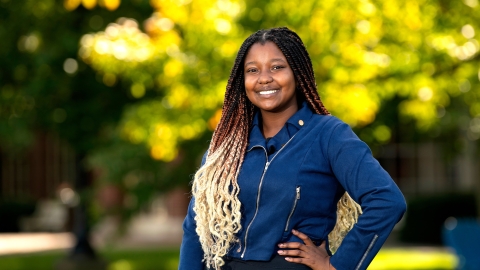 Twity Gitonga poses in a denim shirt and black pants Malesardi Quadrangle.