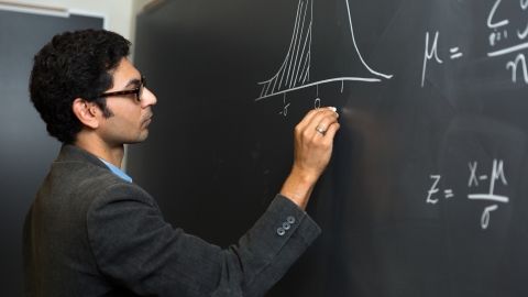 Professor Owais Gilani draws on chalkboard