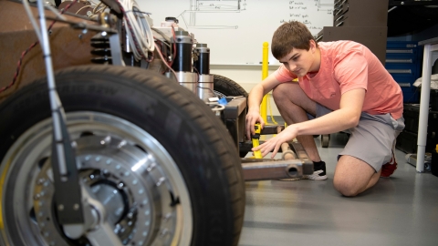 Graham Heckert next to a car, with a wheel in the foreground