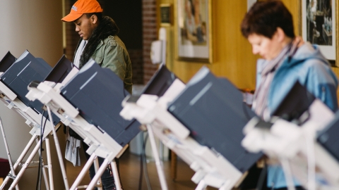 Students cast ballots at voting machines.