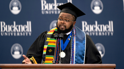 Jawaad "KJ" Benson speaks while standing at a podium