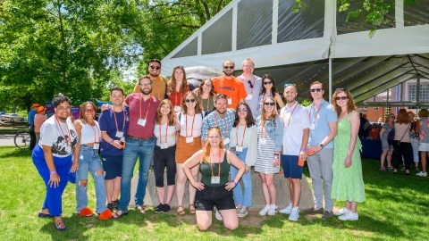 A group of alumni pose in front of the KLARC U Bison during reunion