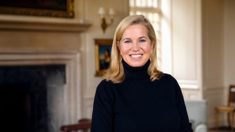 Jessica Livingston smiles in front of a fireplace