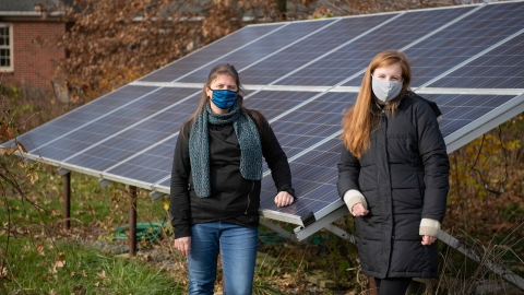Shaunna Barnhart and Maggie Barton '21 stand by solar panels
