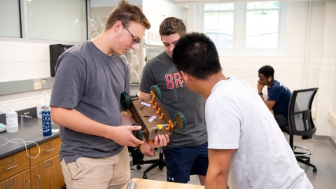 Students standing in a classroom. 