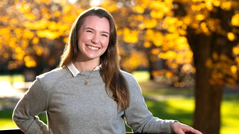 A student stands outside in the fall on Bucknell's campus