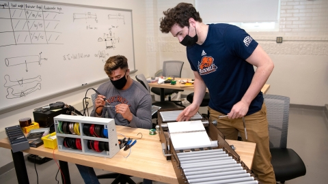 Mechanical engineering majors Michael Bortolot '21 and Nate Romanowski '21 assemble their prototype sanitizing device
