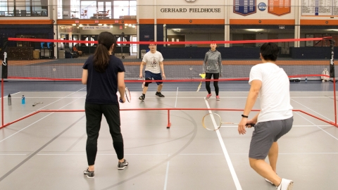 Students playing tennis or badminton. 