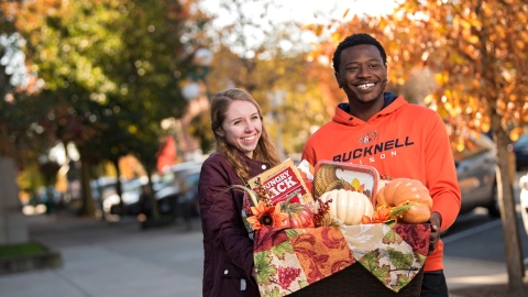 Students with Thanksgiving basket downtown.