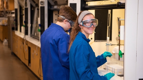 Carly Masonheimer near a hooded workstation in a chemistry lab