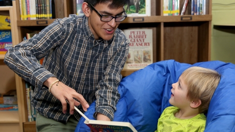 Management 101 student reads to a child