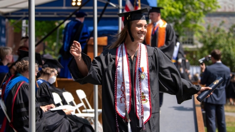 Graduate wearing cap and gown with diploma
