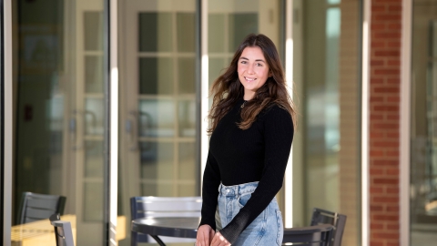 A student stands outside a building on Bucknell's campus