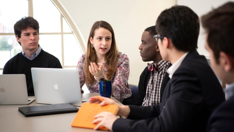 Students discuss around a conference table