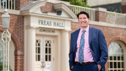 Kevin Mathes in front of Office of Admissions