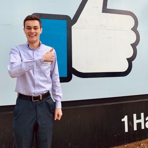Ryan Bailis in front of Facebook sign.