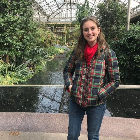 Caroline stands in greenhouse