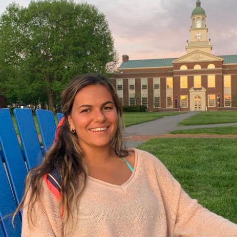 Arianne Evans sits in an Adirondack chair on the Malesardi Quad