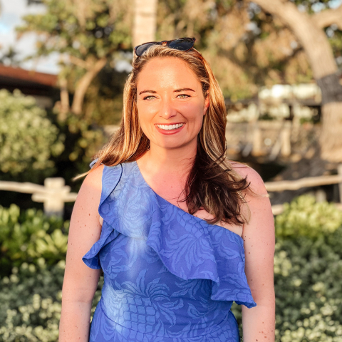 A girl in a blue dress smiles at the camera