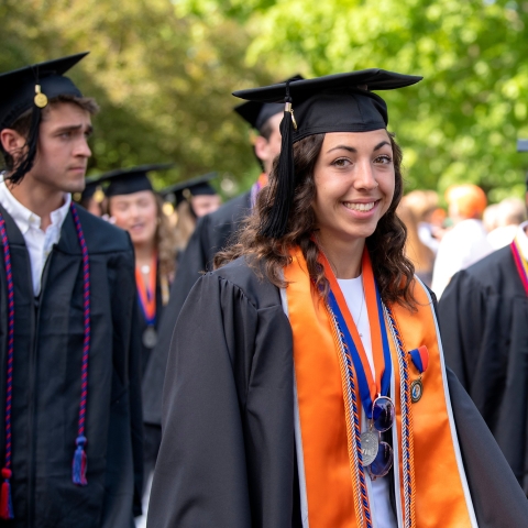 Student processing into commencement in their cap and gown.