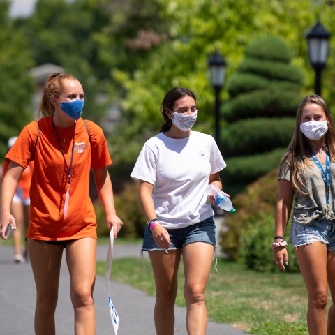 Students in masks walk outside during move-in