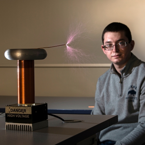 Sparks fly from a Tesla coil next to David Berry