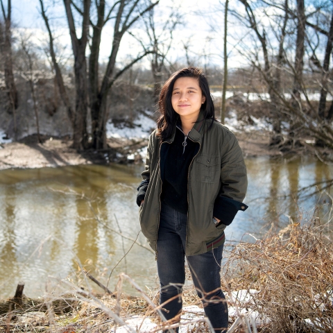 Lam Ngo ’22 stands by a tributary of the Susquehanna River in Lewisburg in the fall