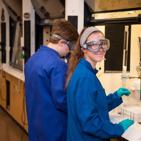 Carly Masonheimer near a hooded workstation in a chemistry lab
