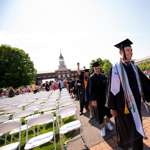 Graduates in cap and gown process into Commencement