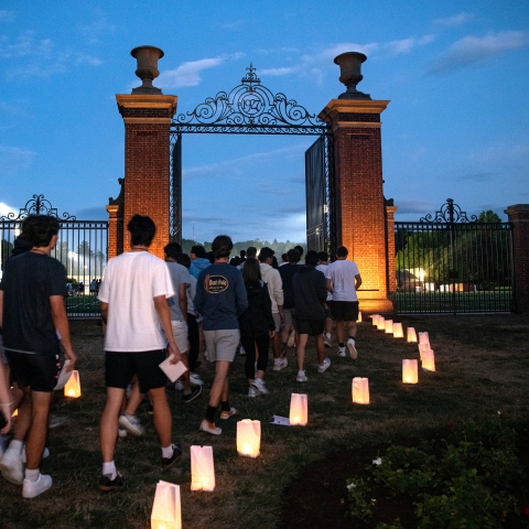 Students enter the Christy Matthewson Gates at twilight