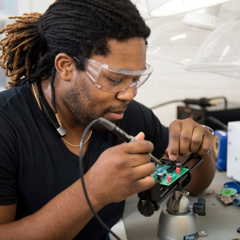 Student soldering a computer chip