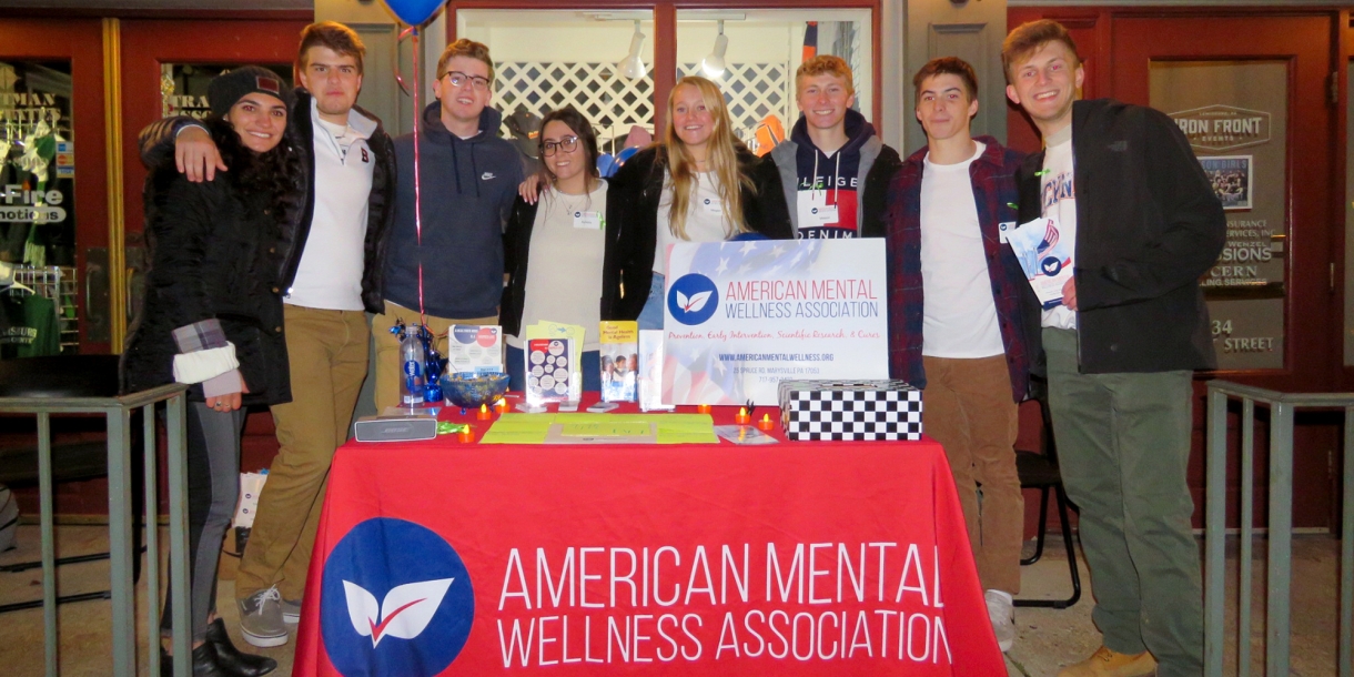 The management 101 group stands behind a table at the Lewisburg Stroll Through the Arts Festival in Lewisburg