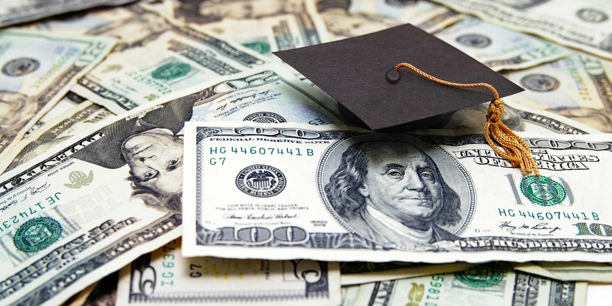 Money laid out with a graduation cap on top.