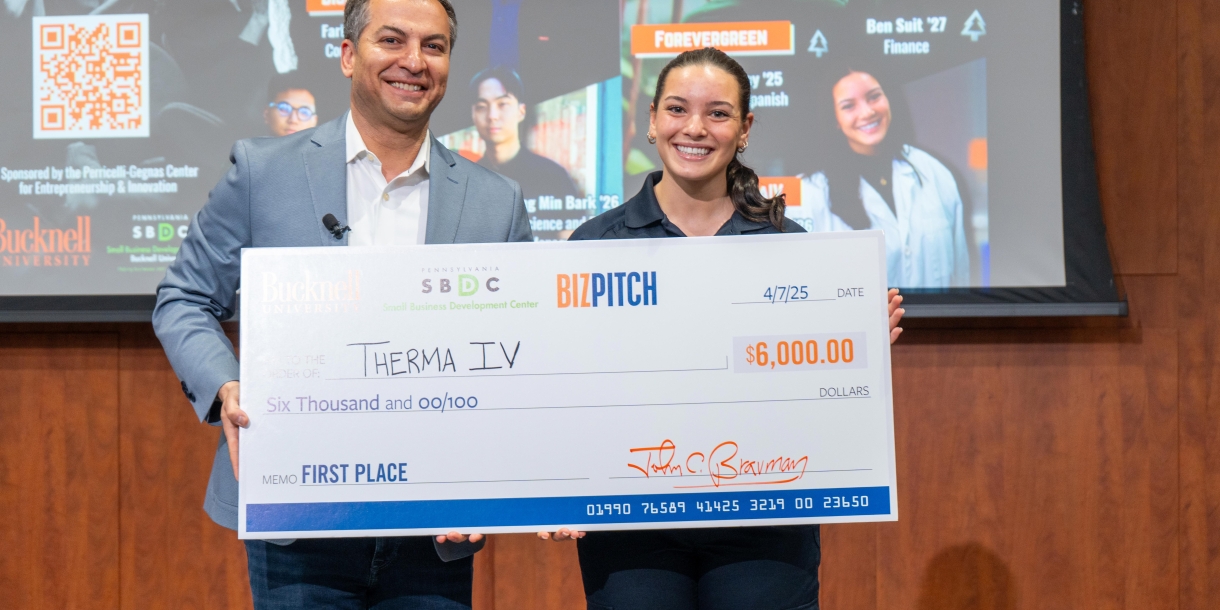 BizPitch 2025 winner Elizabeth Malley ‘26 holding a large check