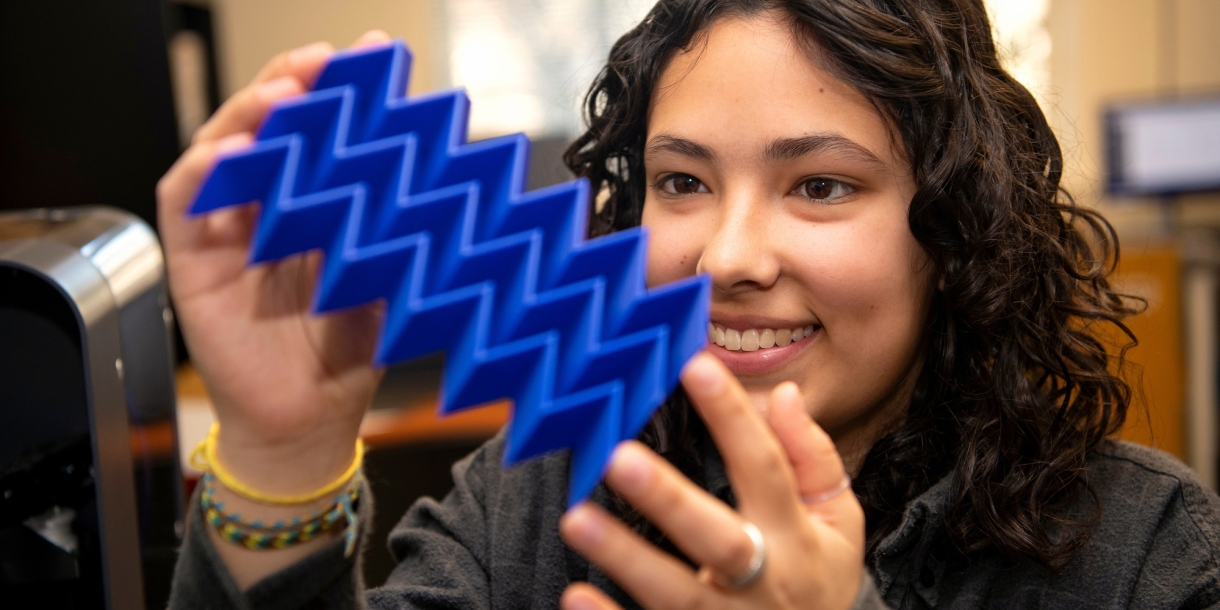 Iona Pitkin &#039;25 looks at a plastic plate with 3D zig-zag design.