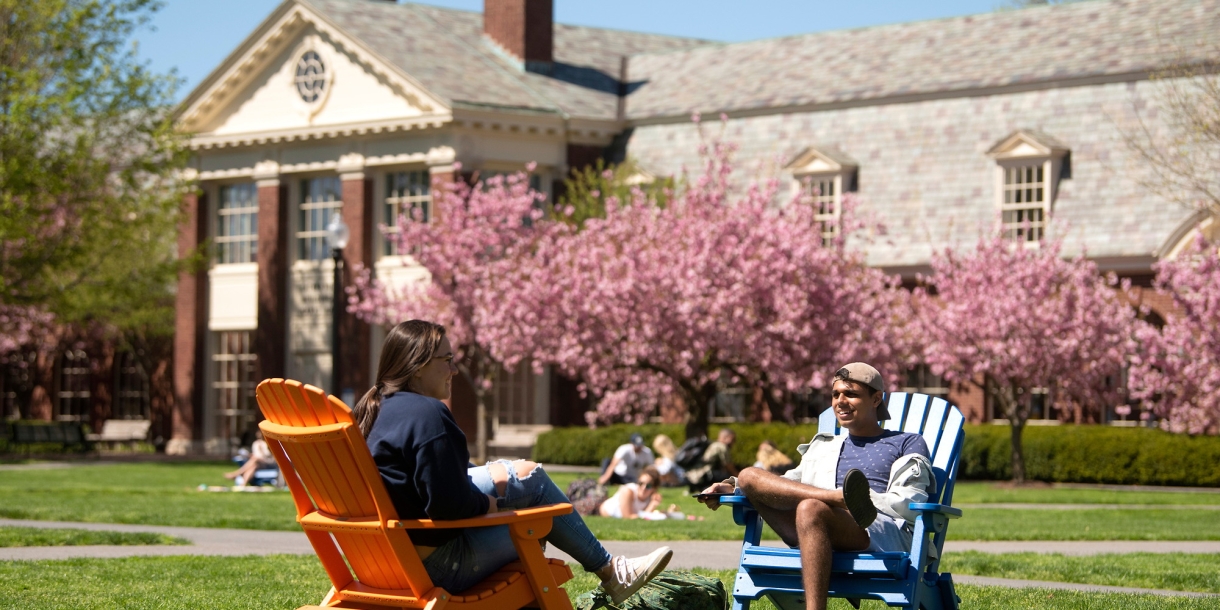 Students sit on Adirondack chairs on Malesardi Quad in Spring.