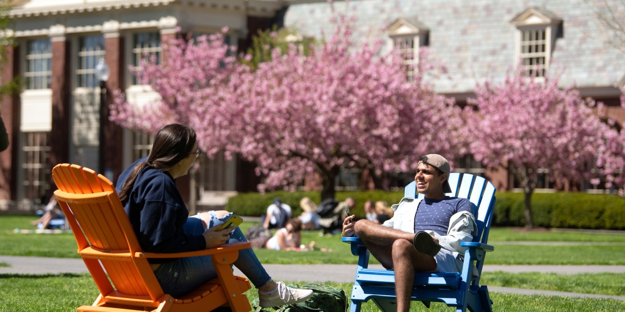 Students enjoying the quad on Adirondack chairs