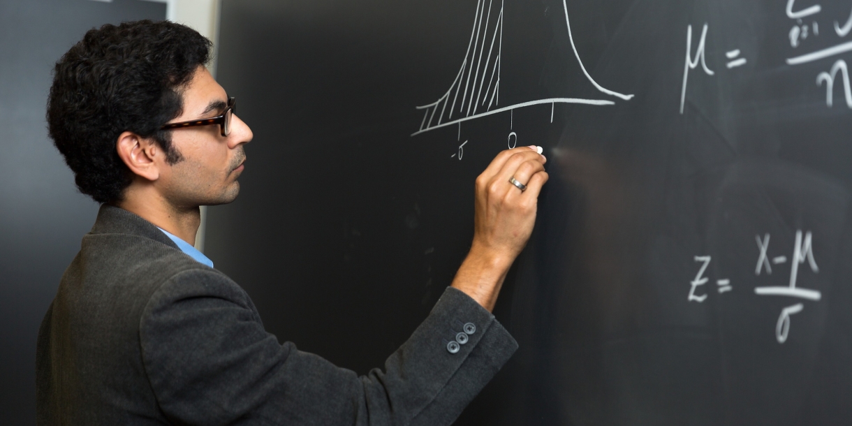 Professor Owais Gilani draws on chalkboard