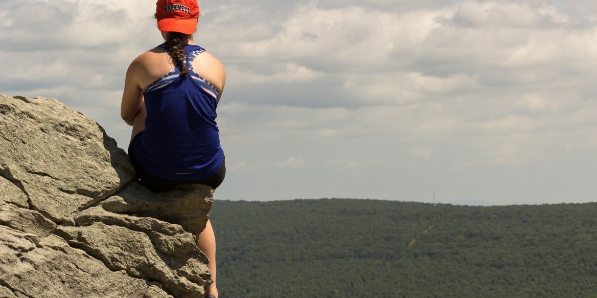 Bucknell student on rocky overhang