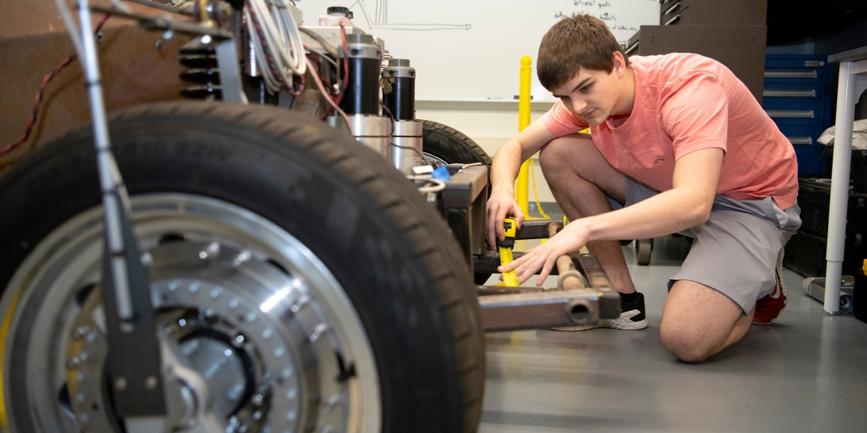 Graham Heckert next to a car, with a wheel in the foreground