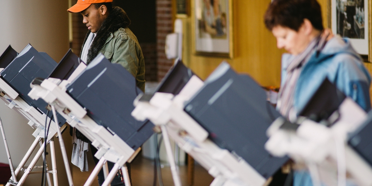 Students cast ballots at voting machines.