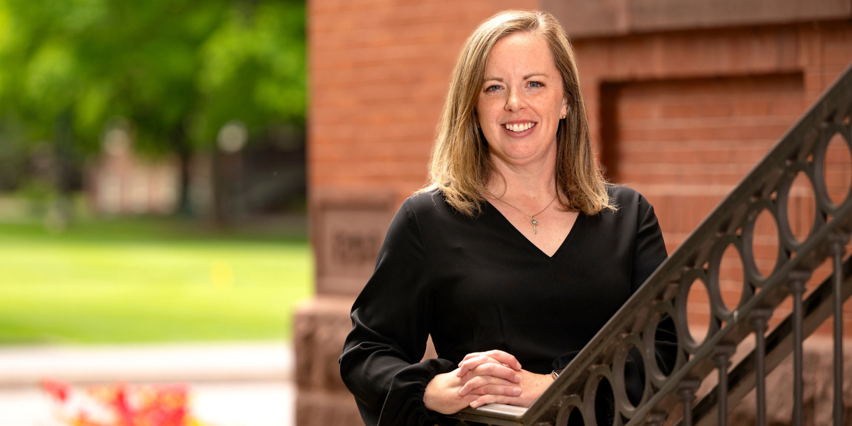 Lauren Baillie smiles on the steps of the Carnegie building at Bucknell.