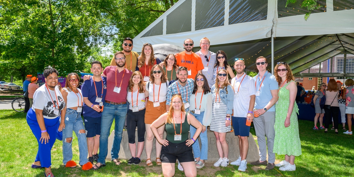 A group of alumni pose in front of the KLARC U Bison during reunion